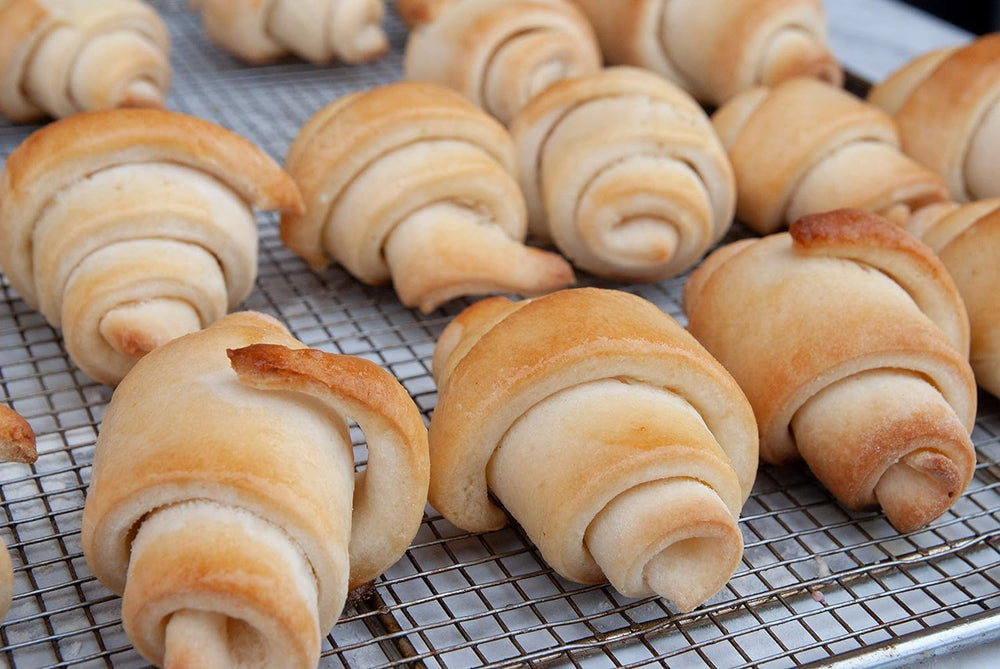 Baked crescent rolls on a tray, warm and fluffy from Mom's Place mix
