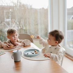 Mushie baby bib features a deep front pocket to catch crumbs and spills.