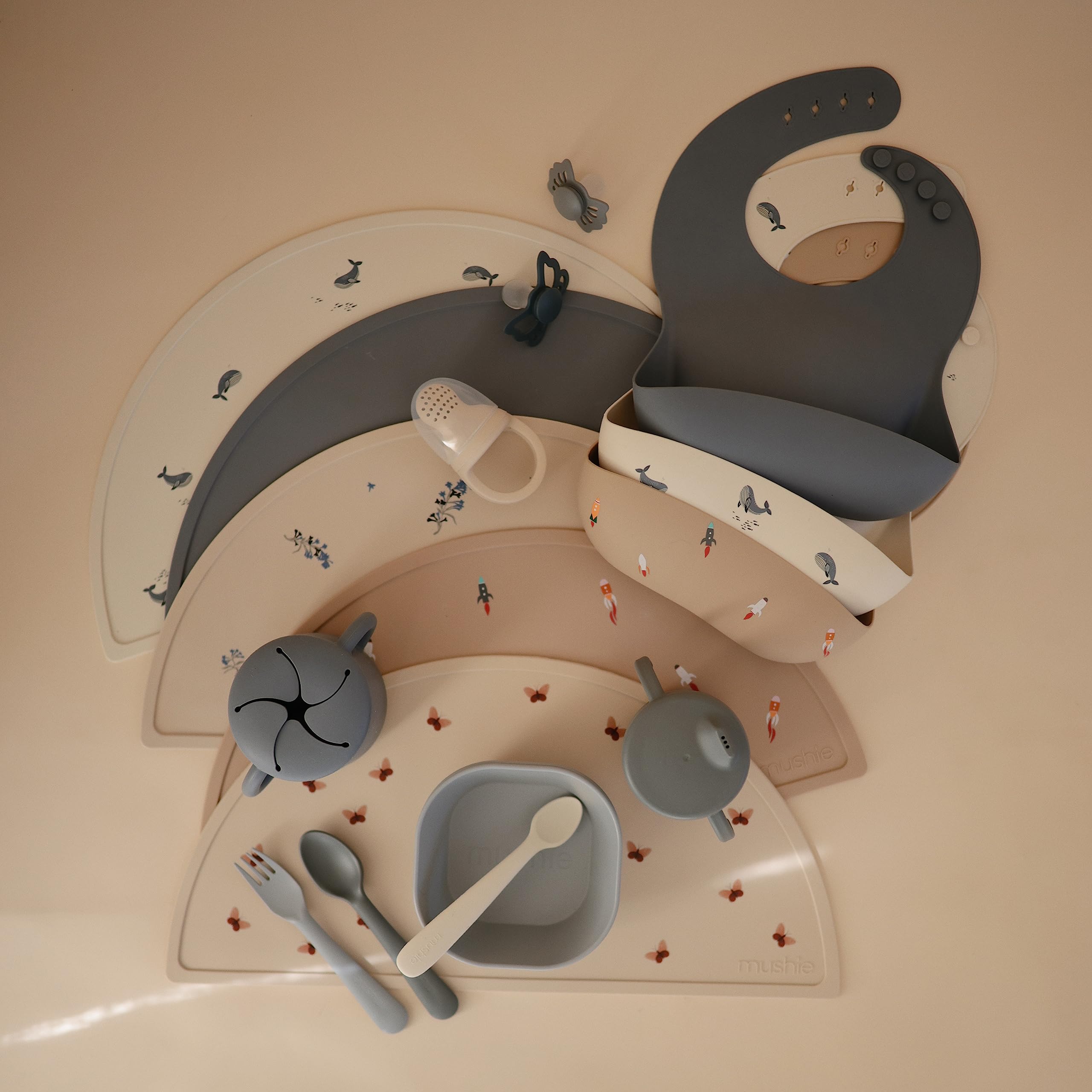 Mushie silicone bib with built-in neck fasteners for a snug, adjustable wear.