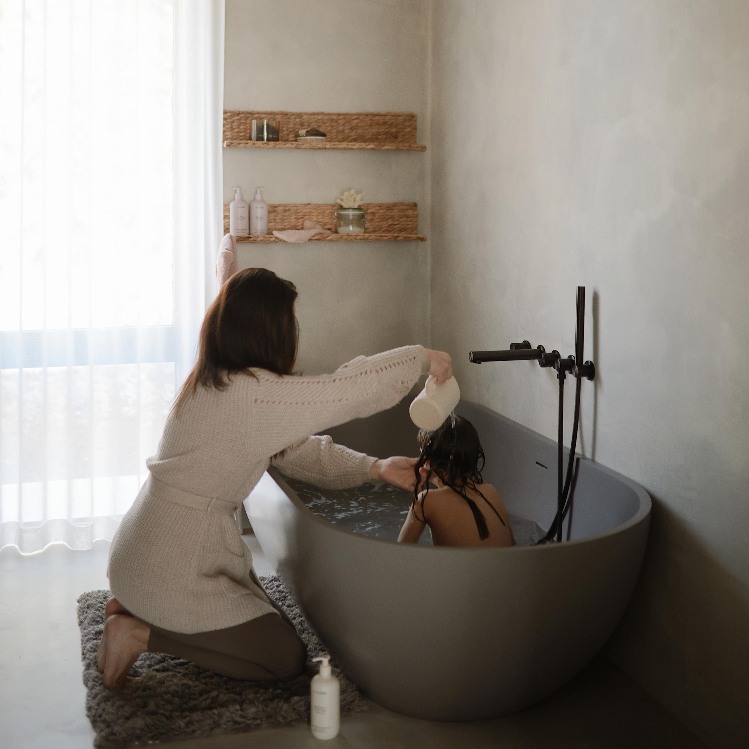 Mushie bath rinse cup with ergonomic handle for easy one-handed use.
