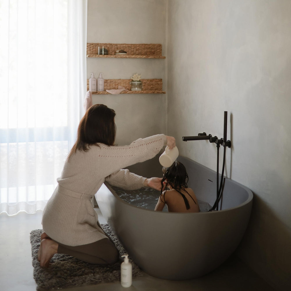 Mushie bath rinse cup with ergonomic handle for easy one-handed use.