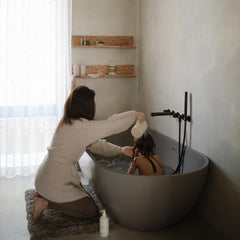 Mushie bath rinse cup with ergonomic handle for easy one-handed use.