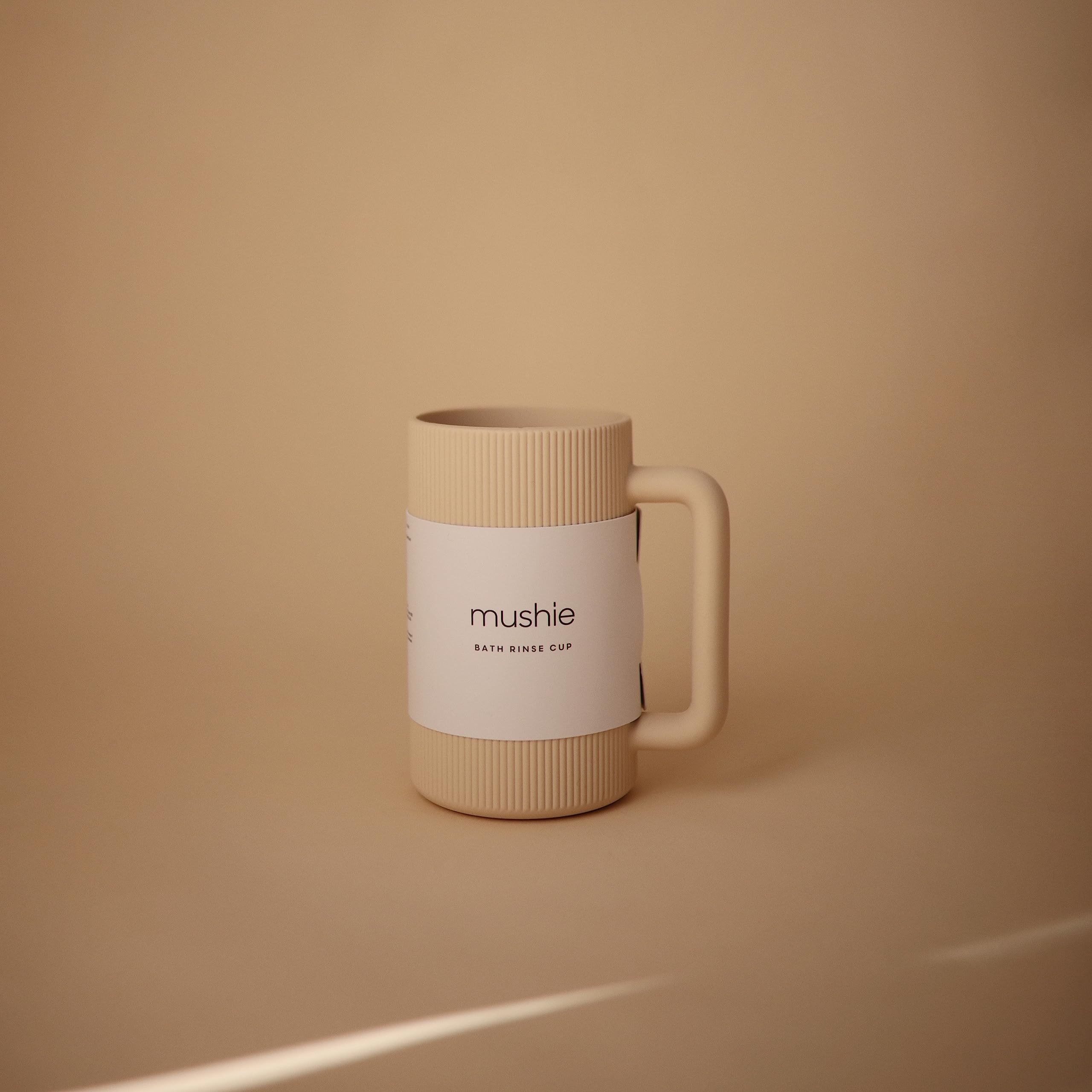 Mushie bath rinse cup shows textured exterior for secure grip while pouring.