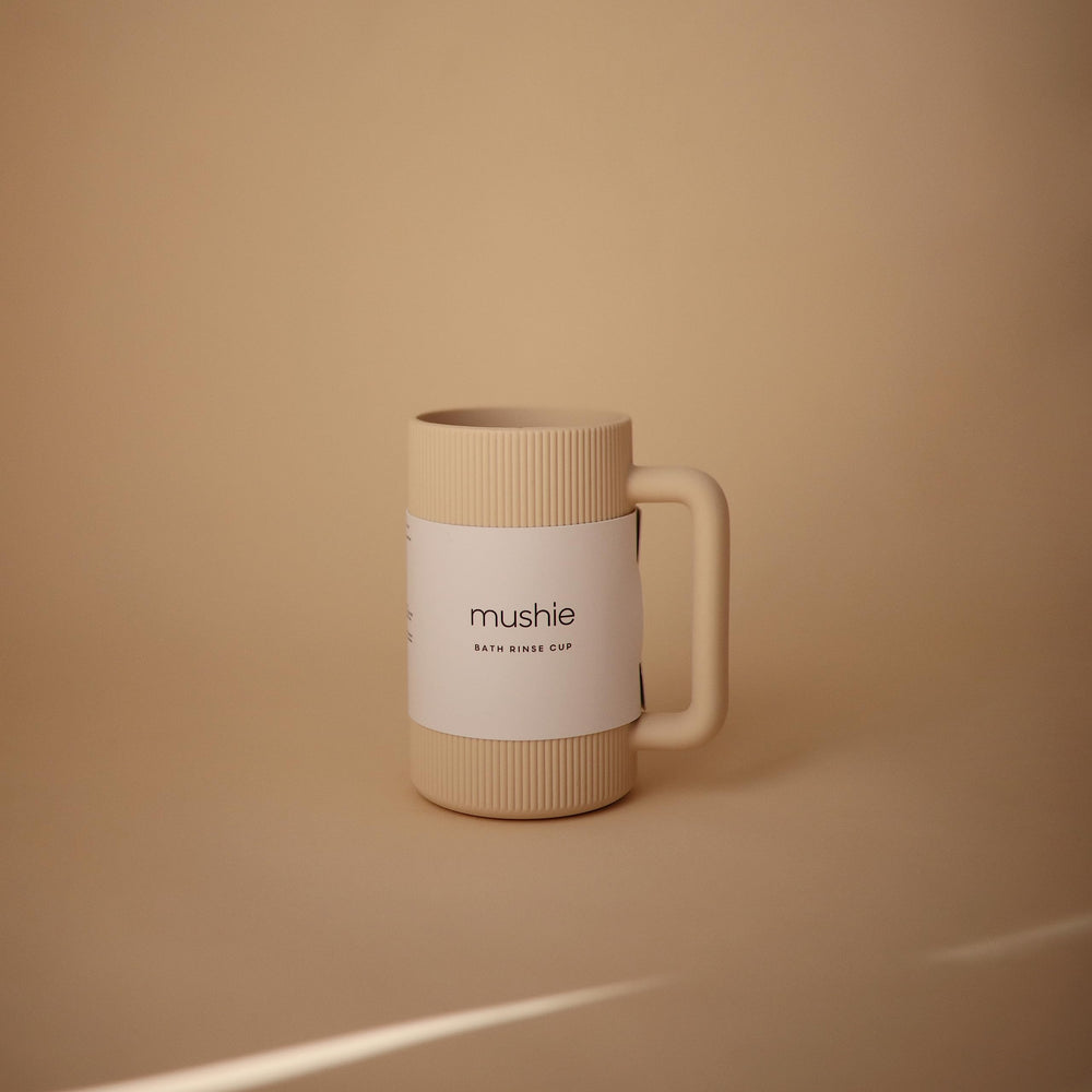 Mushie bath rinse cup shows textured exterior for secure grip while pouring.