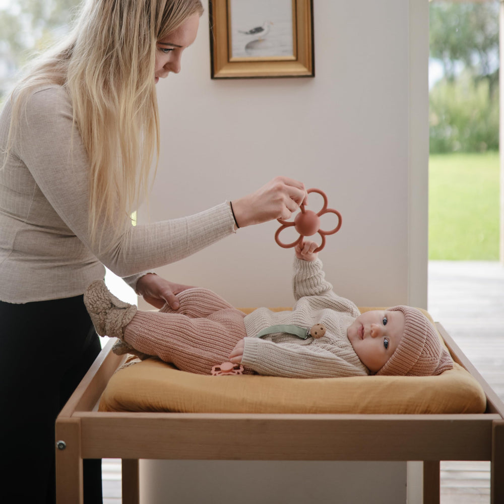 Dusty Rose Daisy Rattle Teether easy-grip handles fit small hands.