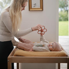 Dusty Rose Daisy Rattle Teether easy-grip handles fit small hands.