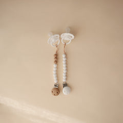 Mushie Hera pacifier clip close-up shows screw-free silicone clasp for safer use.