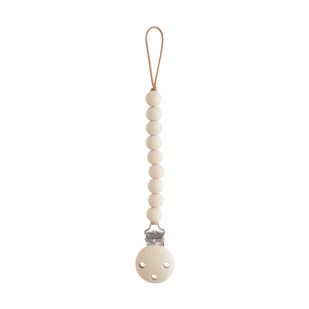 Mushie Hera pacifier clip packaging for easy gifting and travel-ready organization.