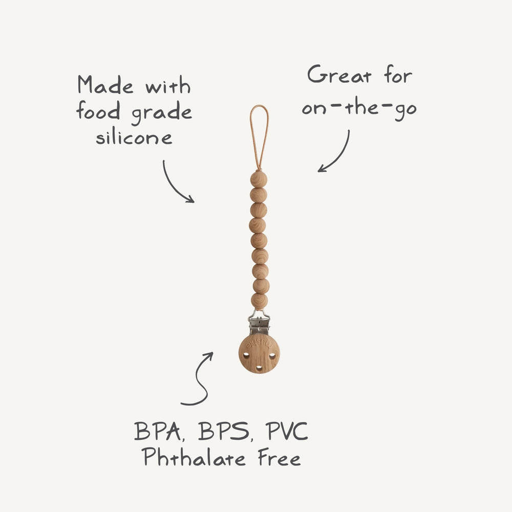 Mushie Hera pacifier clip usage scene demonstrates convenient accessible pacifier control.