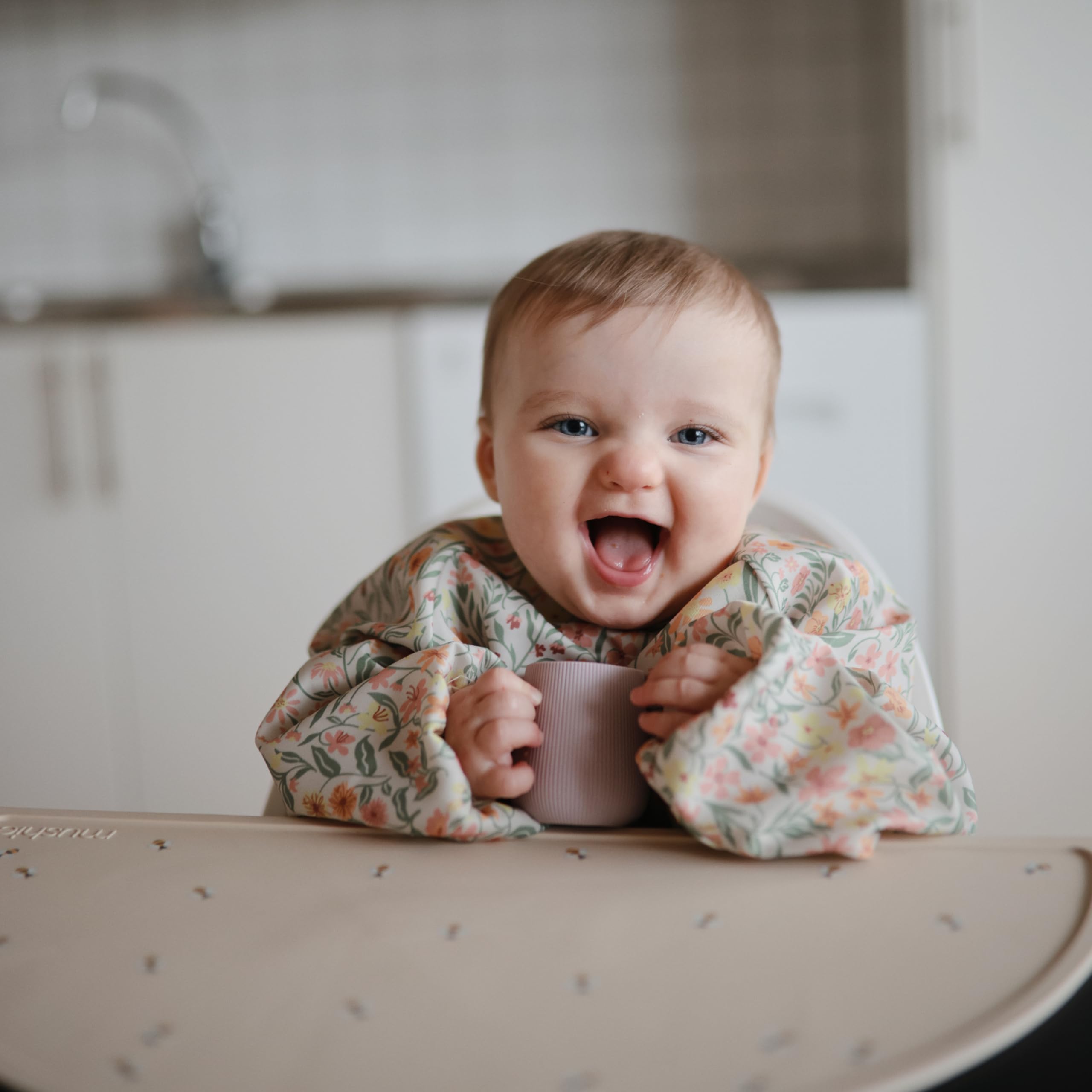Mushie pastel blooms bib shown during meals and art projects for versatile use.