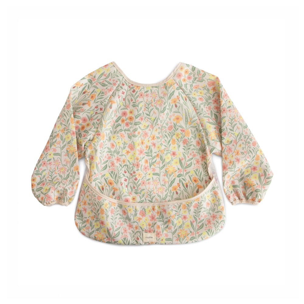 Mushie long sleeve bib pastel blooms close-up highlights spill-catching design for mealtimes.
