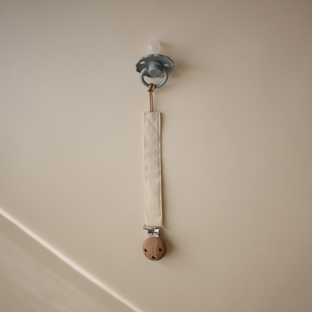 Mushie clip featuring faux wood silicone clasp for secure attachment