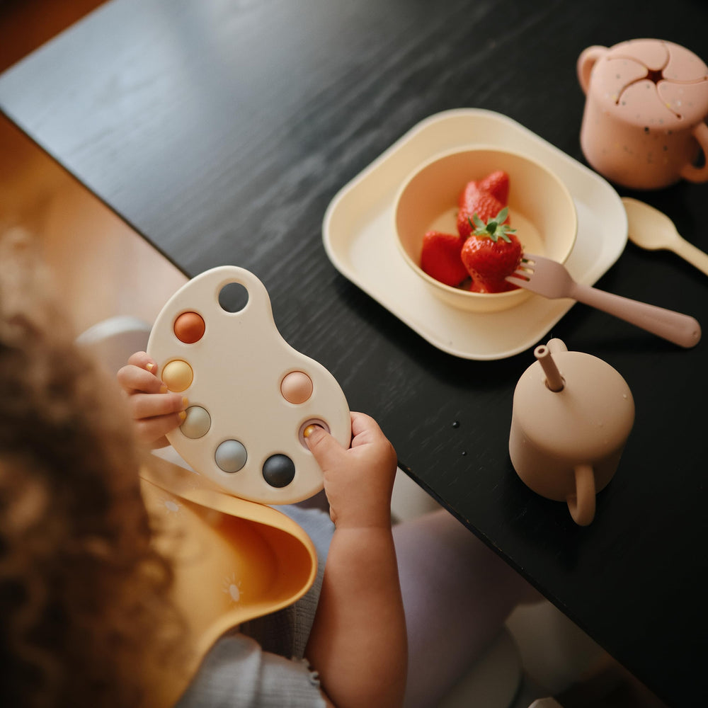 Mushie Paint Palette Press Toy BPA-free frame supports safe handling.