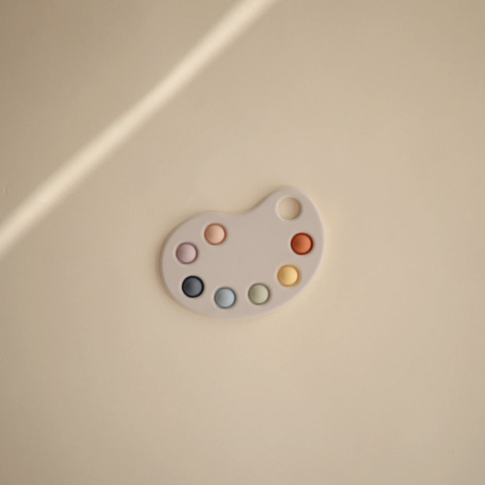 Mushie Paint Palette Press Toy soft colors emphasizing calm, engaging play.