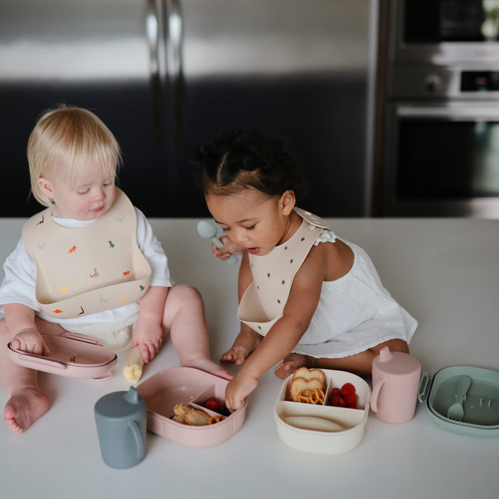 Mushie silicone bib features a deep pocket to contain mess.
