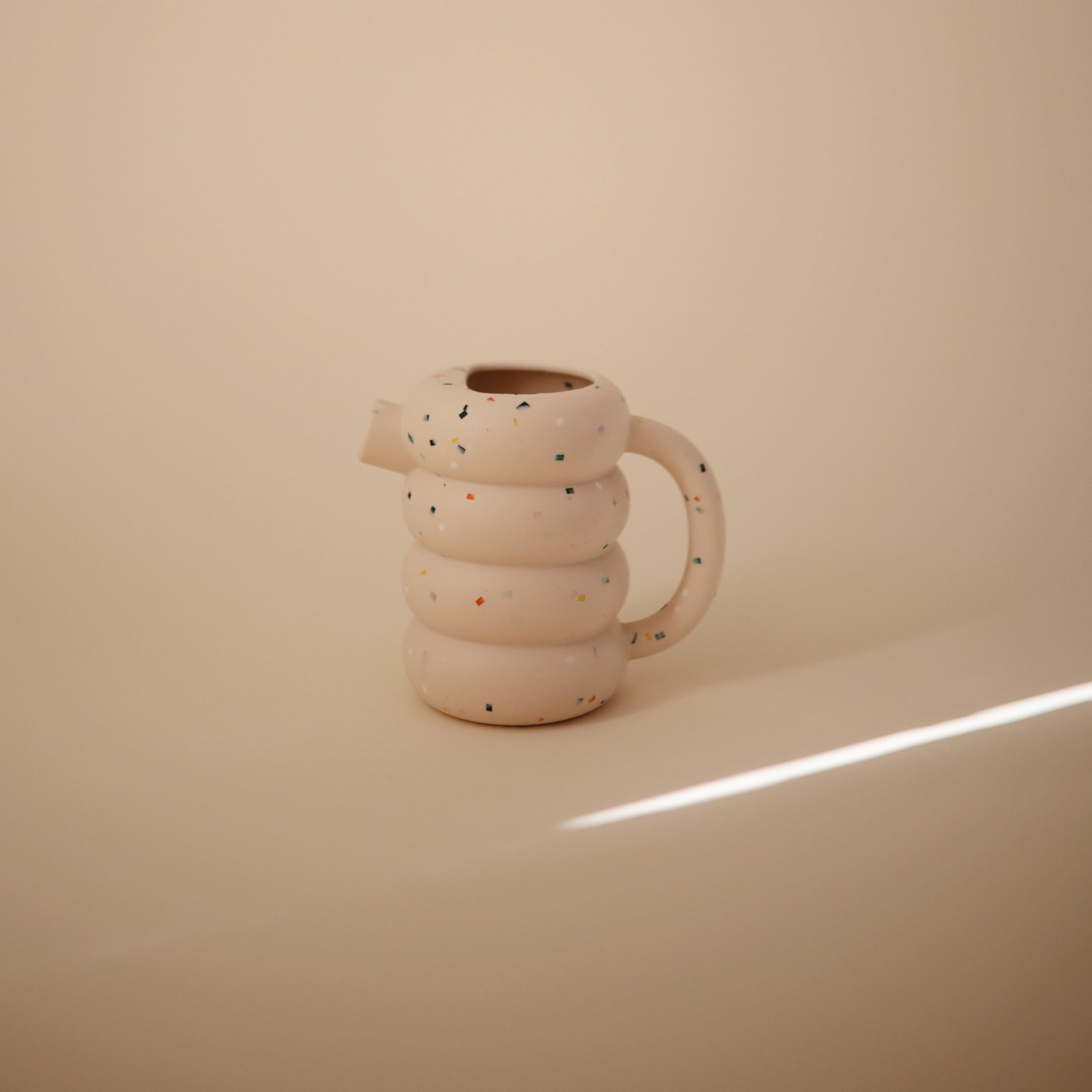 Mushie silicone watering can on a kitchen rack after top-shelf dishwasher safe cleaning.