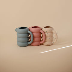 Soft silicone texture ready for gentle pouring during bath or outdoor water play with Mushie.