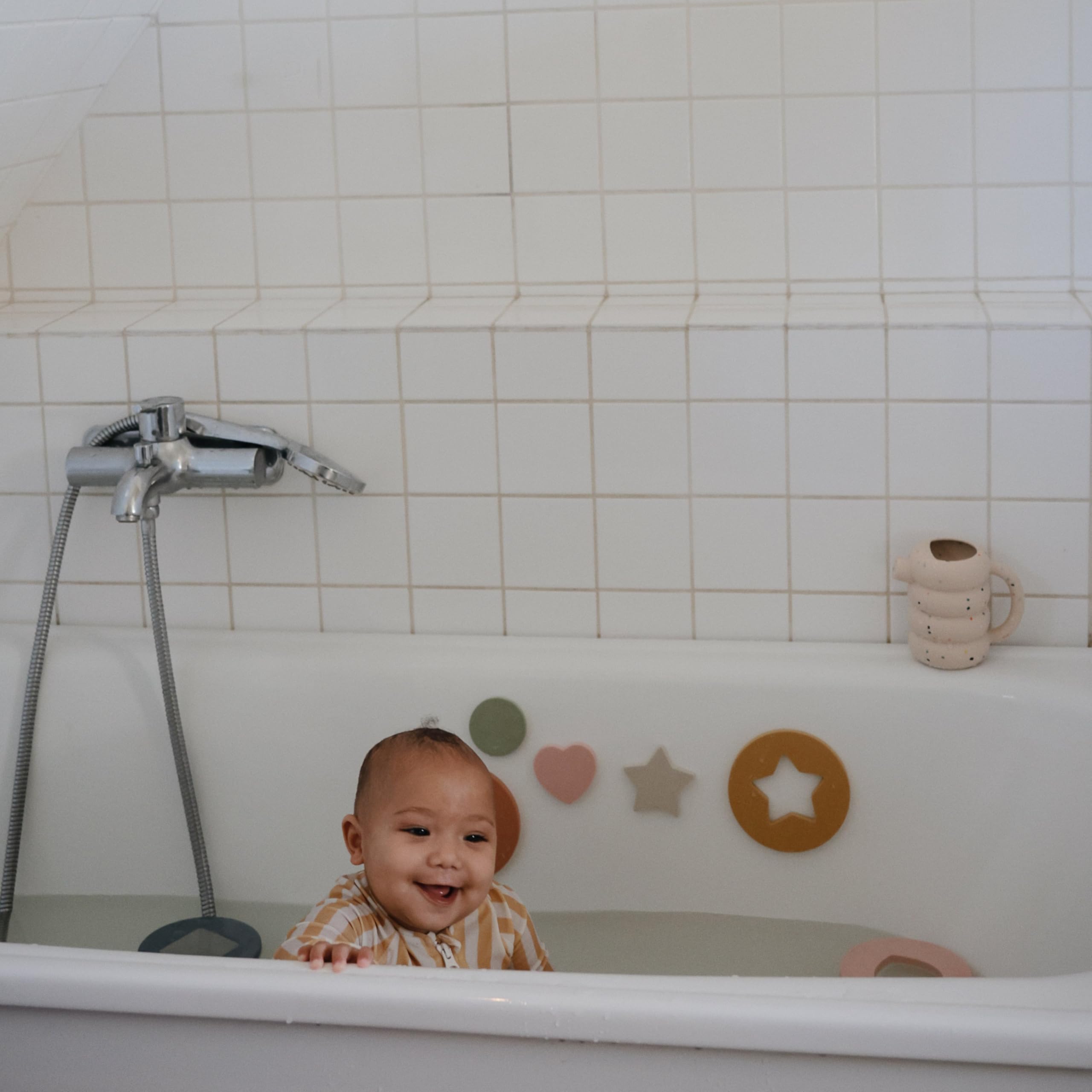 Lightweight, toddler-friendly Mushie watering can supports independent play during bath time.