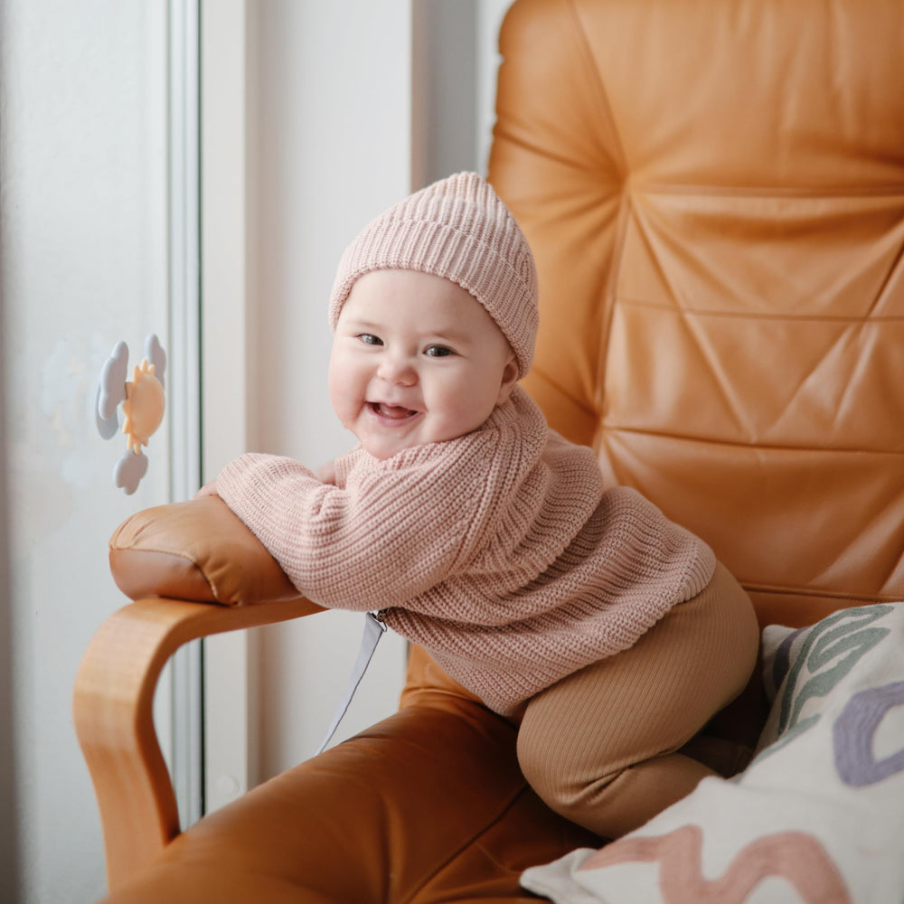Mushie Sunshine Suction Spinner Toy sticks to a highchair for mess-free play.