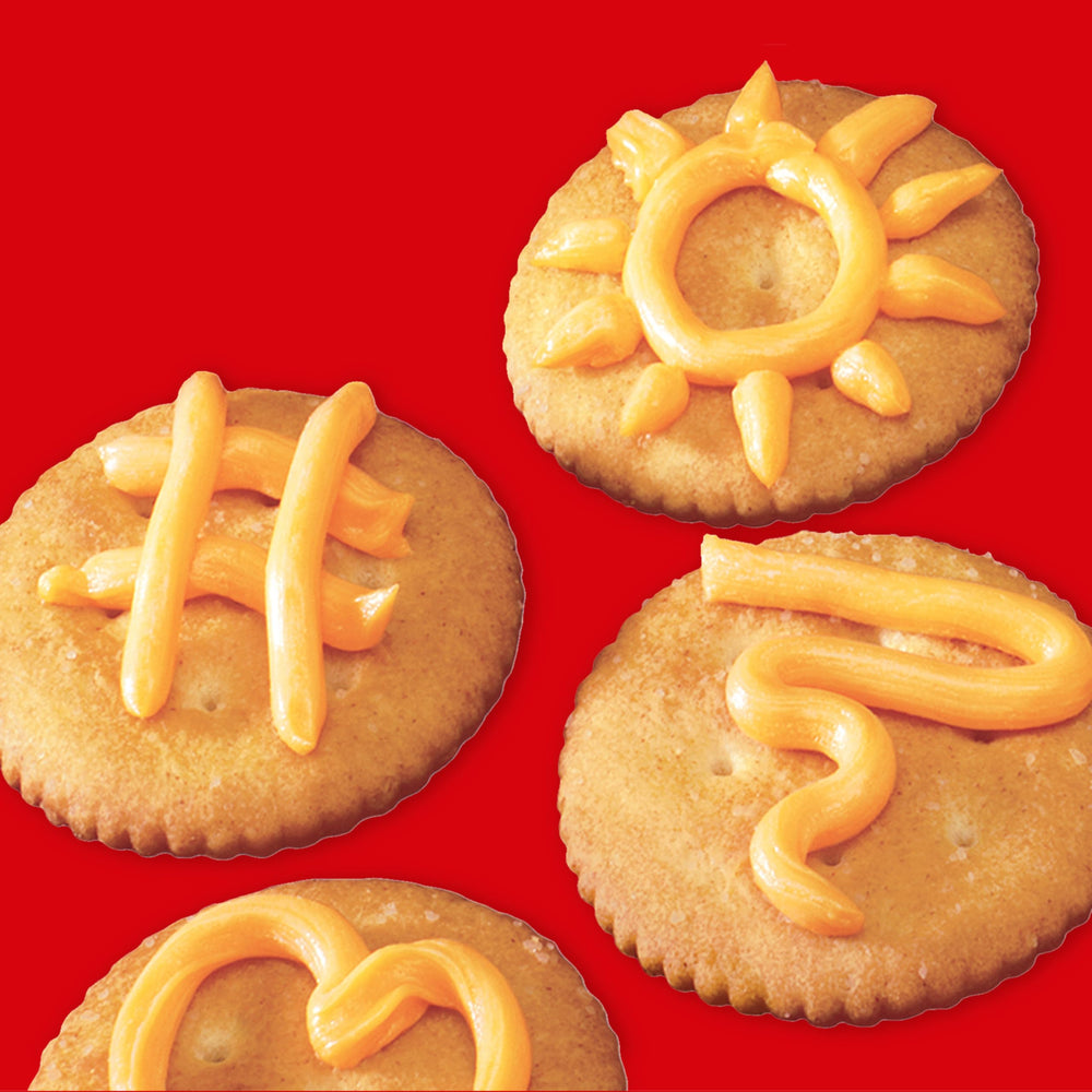 NABISCO Easy Cheese Cheddar spray dispensing action for quick snack assembly.