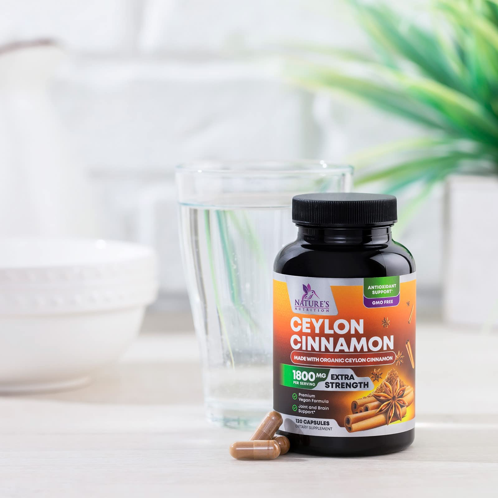 Nature's Nutrition Organic Cinnamon capsules displayed beside apples for a wellness routine.