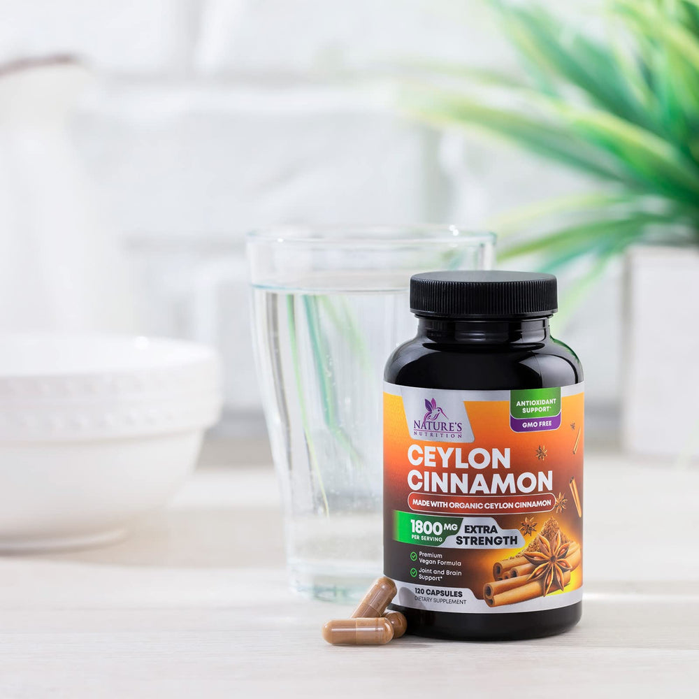 Nature's Nutrition Organic Cinnamon capsules displayed beside apples for a wellness routine.