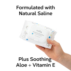 Baby using Nolla wipes on nose with saline cleanse.