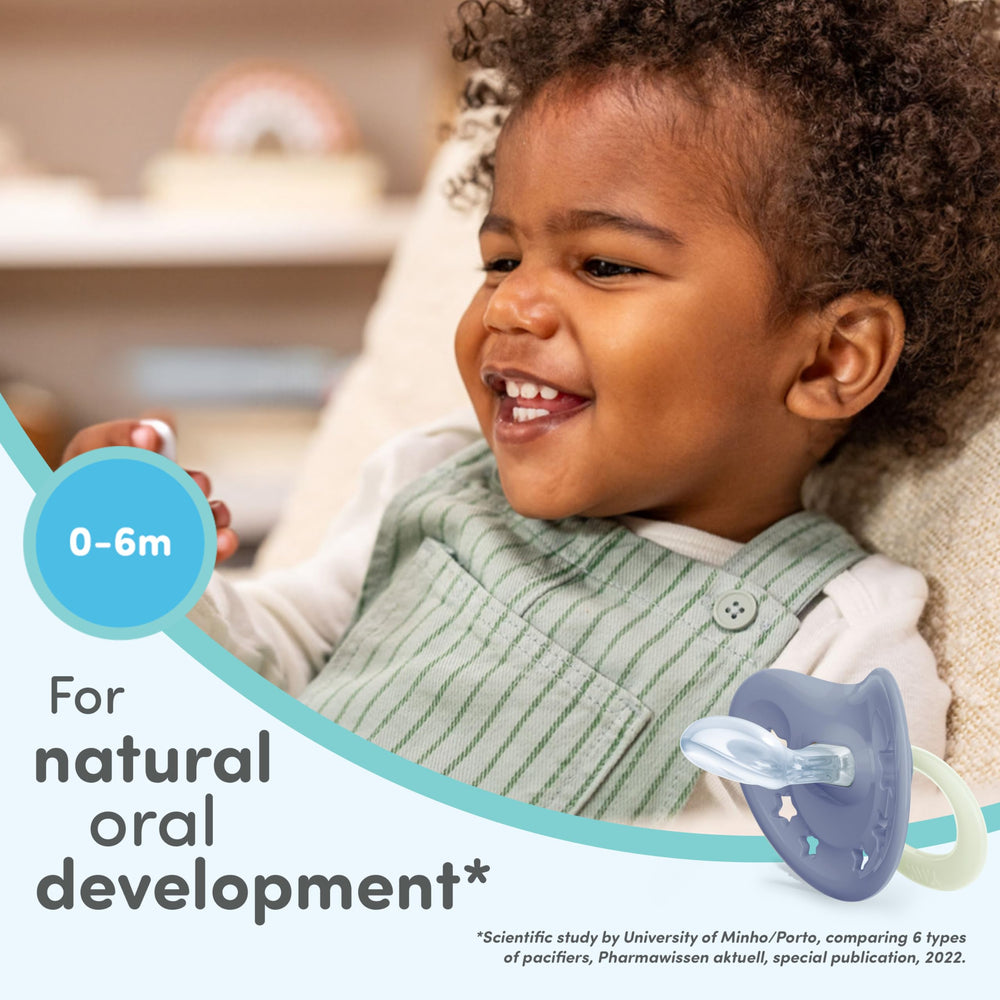 NUK pacifier with heart-shaped shield under baby's nose for easy breathing.
