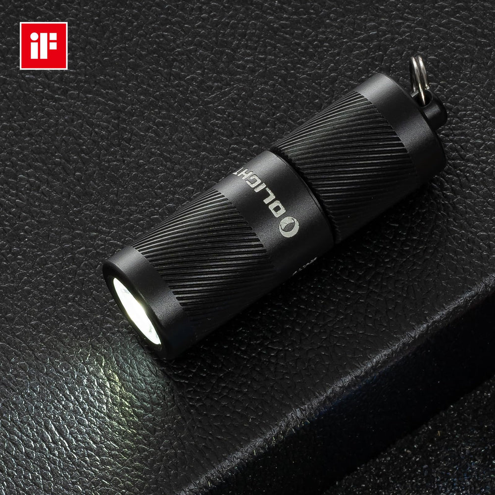 OLIGHT I1R 2 Pro EOS warm ambient beam on a nightstand.