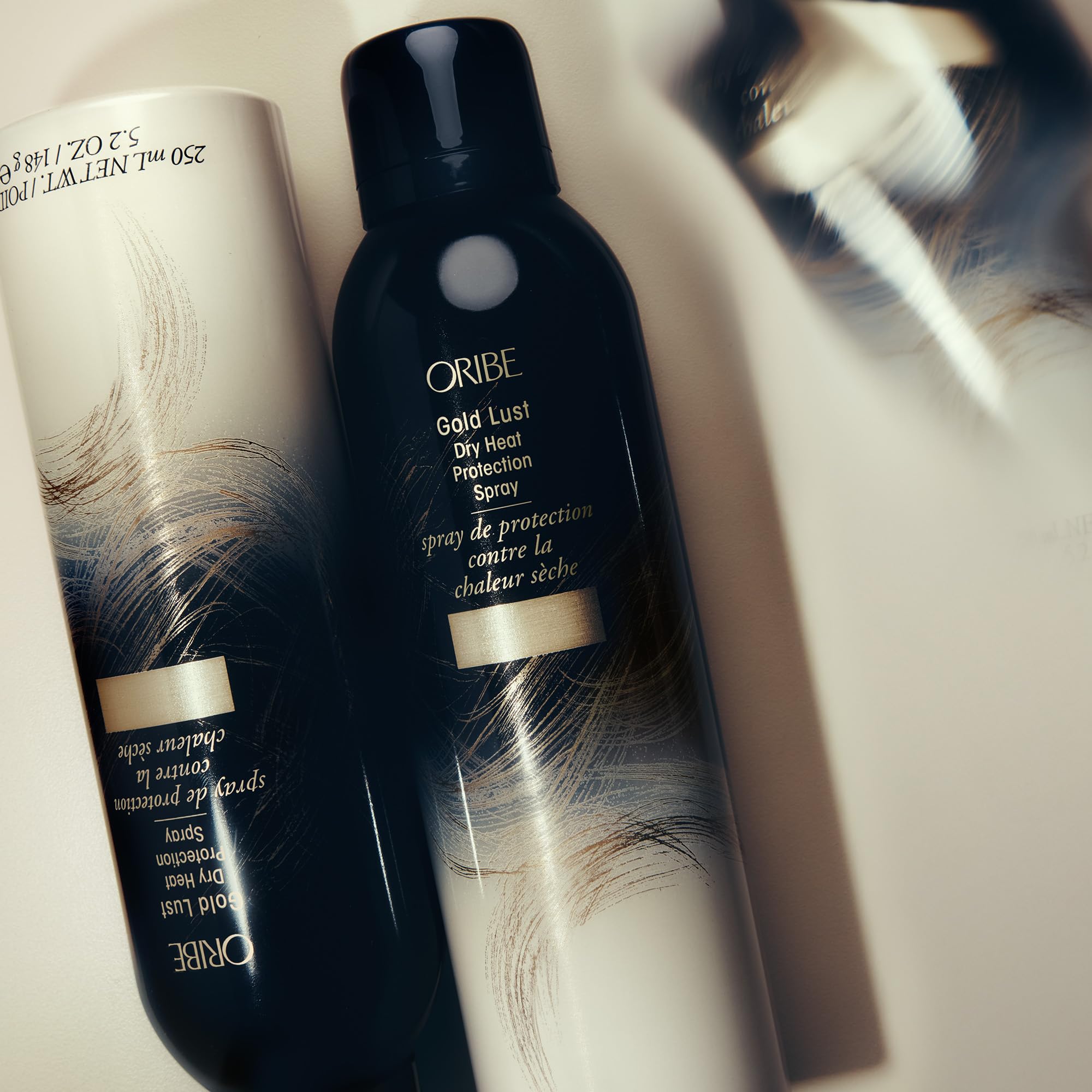Oribe Gold Lust bottle beside vanity and tools in a bathroom
