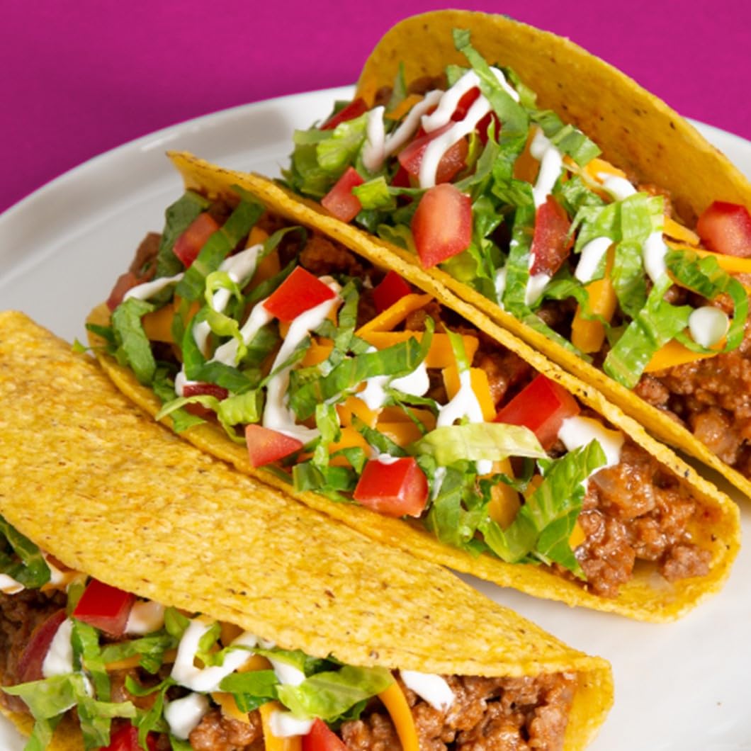 Ortega seasoning sprinkled on sizzling pan for quick taco night