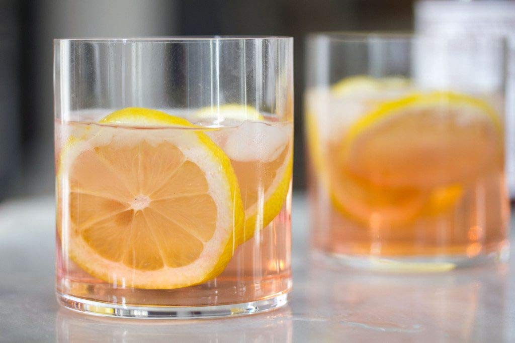 Peychaud's bottle being poured hints at controlled flavor boosts.
