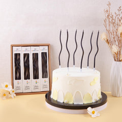 PHD CAKE long thin black spiral candles enhance modern birthday cake decor.