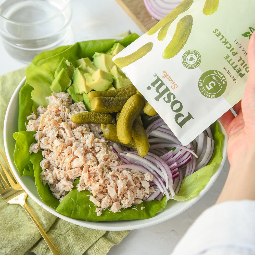 Poshi sea salt dill pickles in store display emphasizing premium snacking.