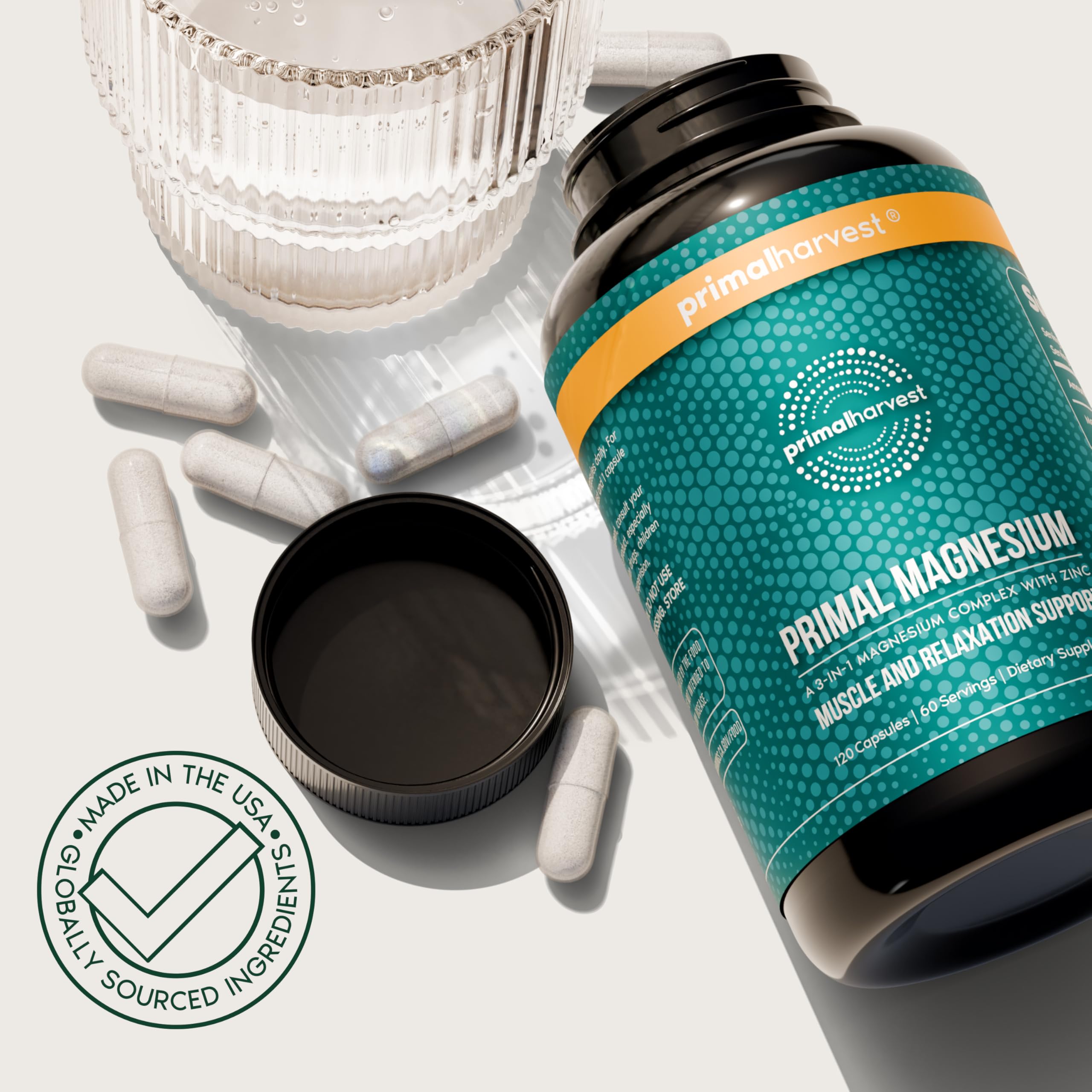 Glass of water beside Primal Harvest Magnesium Complex bottle.