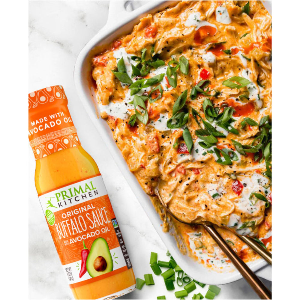 Primal Kitchen No Dairy Buffalo Sauce on burger for zesty flavor.