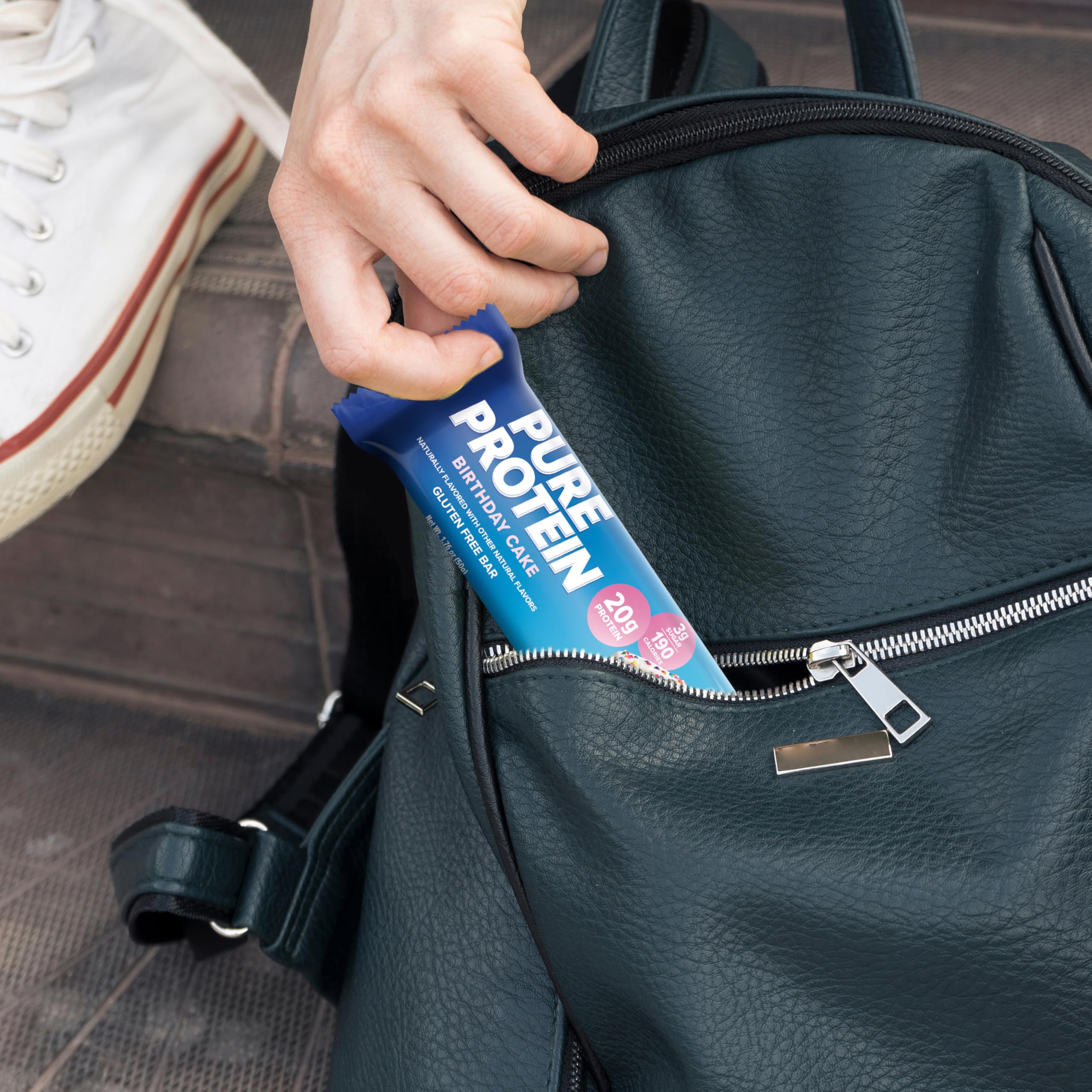 Pure Protein Birthday Cake bar in backpack, ideal pre- or post-workout fuel.