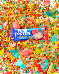 Pure Protein Fruity PEBBLES Bar split to reveal soft interior and flavor.