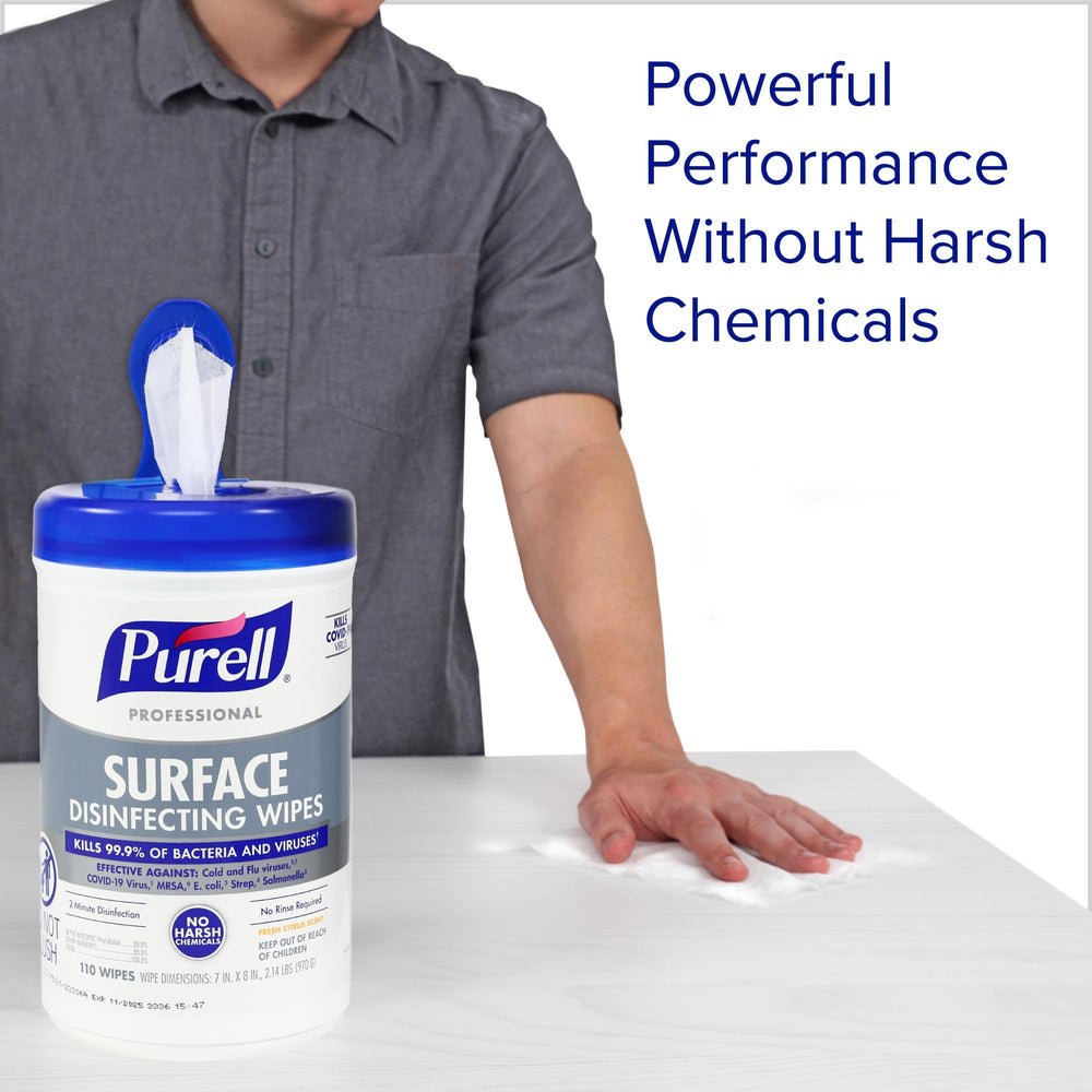 Wipe being used on a desk to sanitize a workspace with Purell