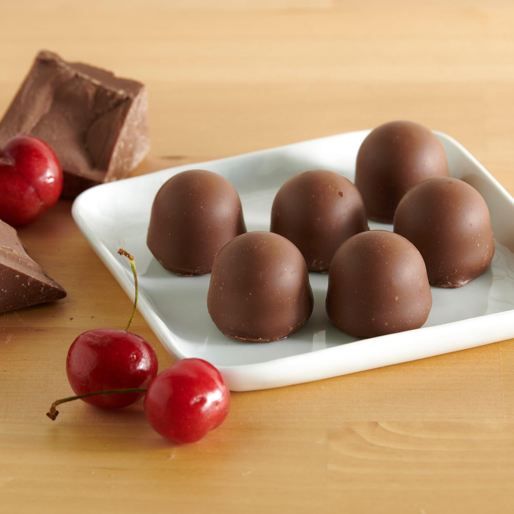 Queen Anne milk chocolate coating close-up, creamy center visible.