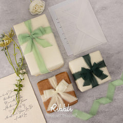 Ribbli fringe chiffon ribbon wrapped around a wedding invitation for instant elegance