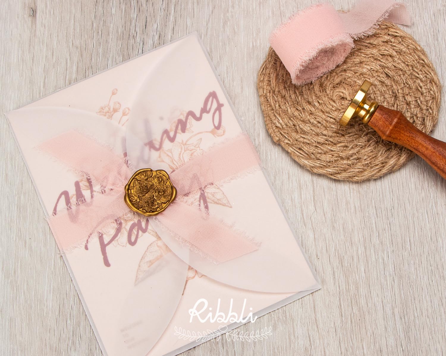 Ribbli blush pink ribbon used to wrap wedding invitations and bouquets.