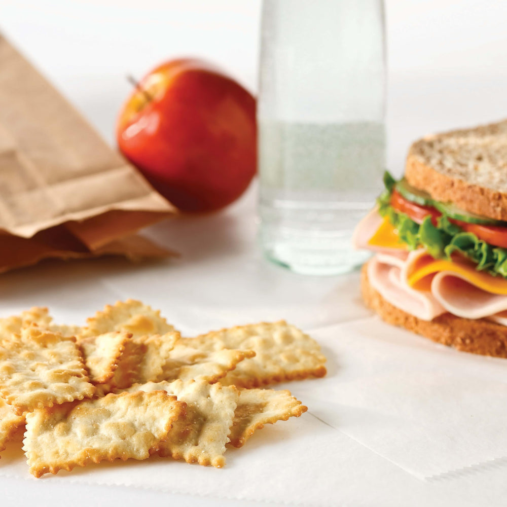 Ritz Toasted Chips Cheddar serving beside a dip and cheese board.