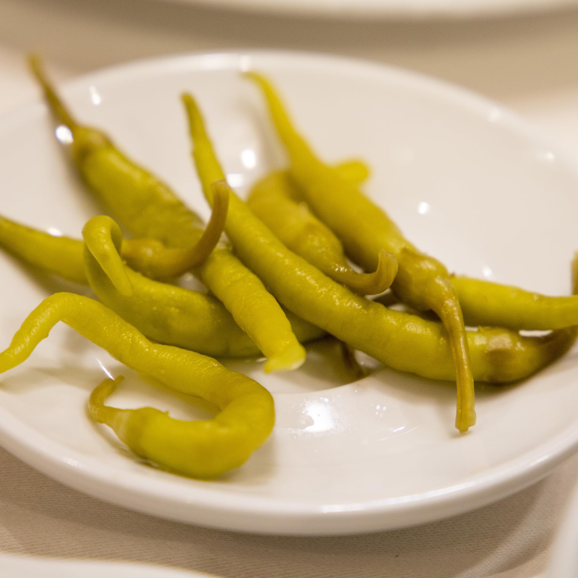 Sanniti Guindillas Piparras peppers with vinegar glaze, highlighting traditional preservation method.