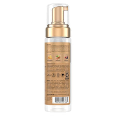 Hands divide damp hair to apply 2-3 pumps per section for styling.