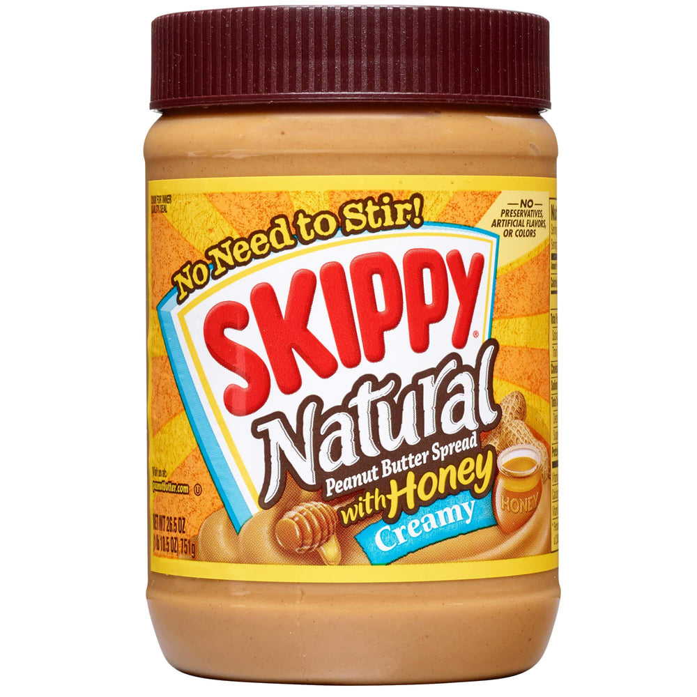 SKIPPY Natural Creamy Peanut Butter with Honey jar pour showing smooth texture for easy spreading