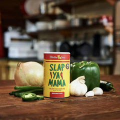 Slap Ya Mama Cajun seasoning shaker pouring for balanced heat in meals.