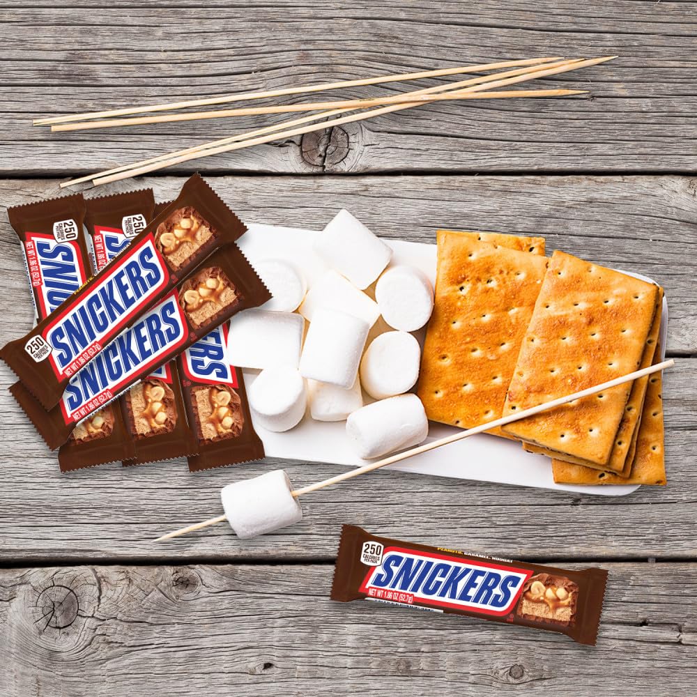 Trick-or-treat bags being filled with Snickers for Halloween treats.