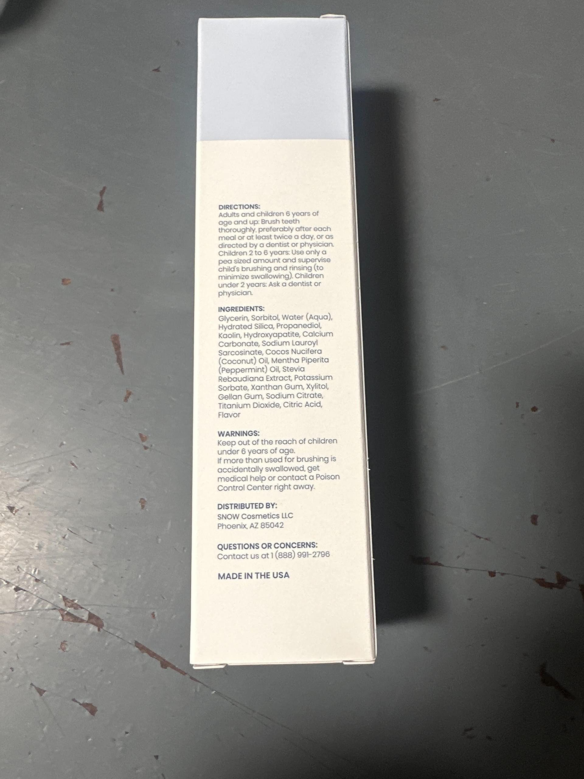 Snow toothpaste on a toothbrush, designed for adult daily use.