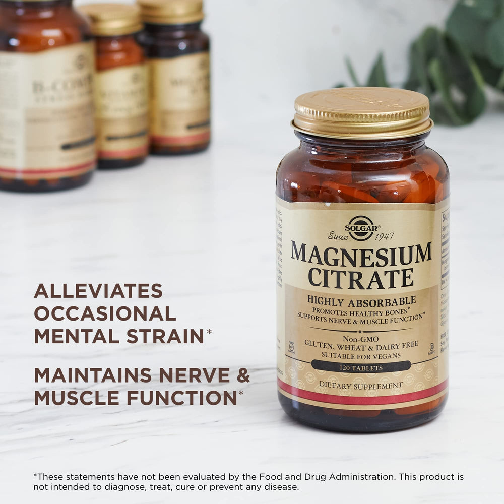 Solgar Magnesium Citrate tablets on a surface with water for daily intake.